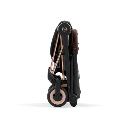 Folded stroller with rose gold accents on a black background